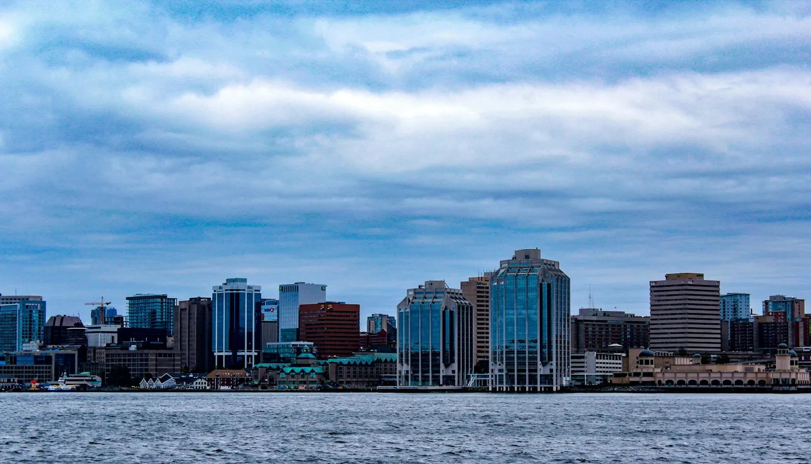 The Halifax skyline across the harbour under a cloudy sky